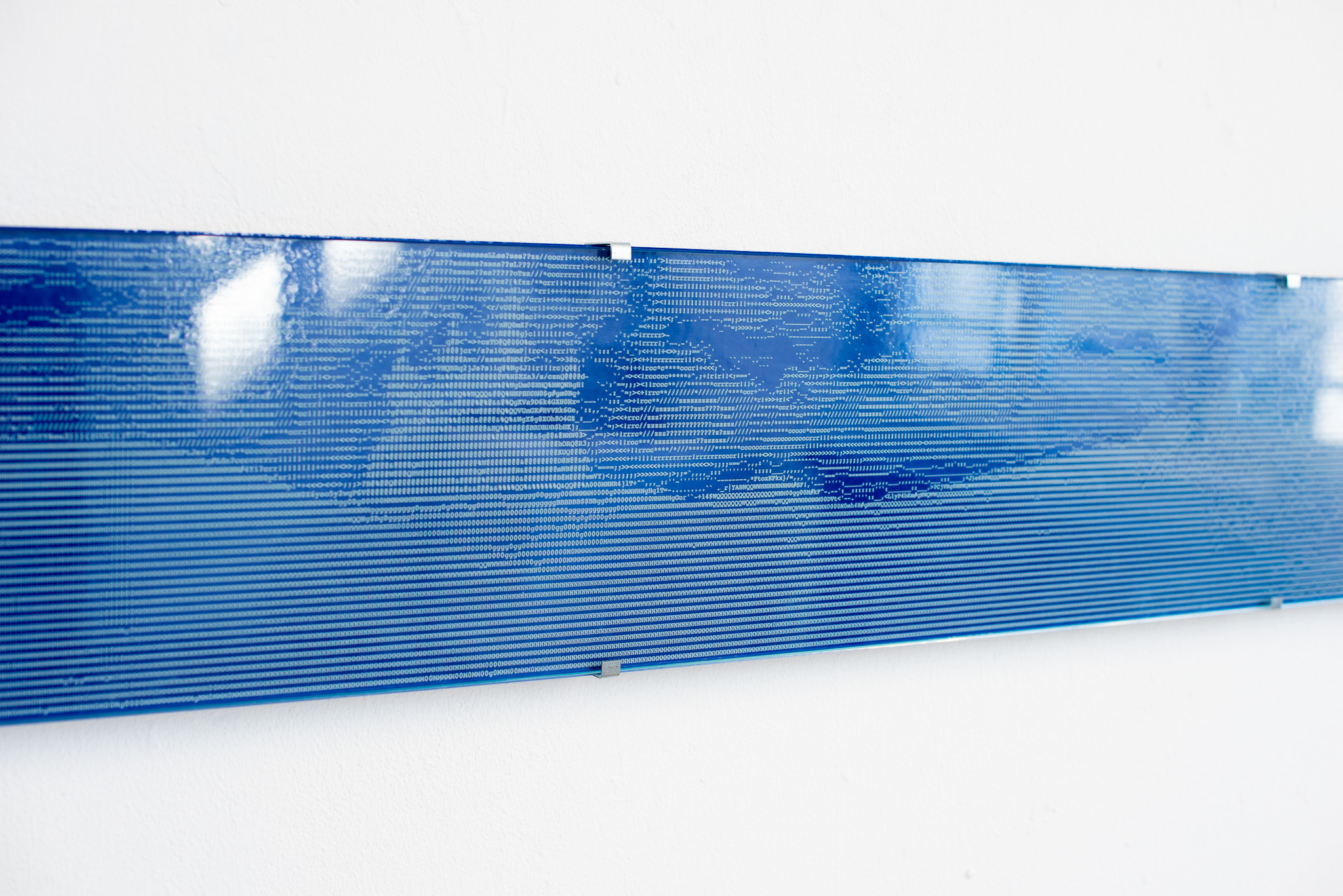 A close-up shot of the engraved ASCII art on the glass, showing the texture and detail.